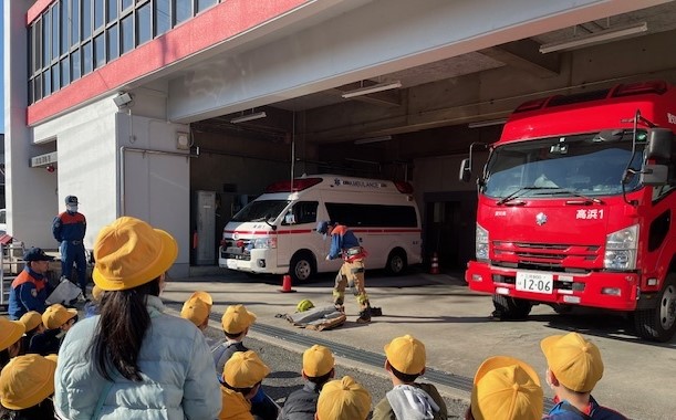 訓練する消防士を応援する小学生