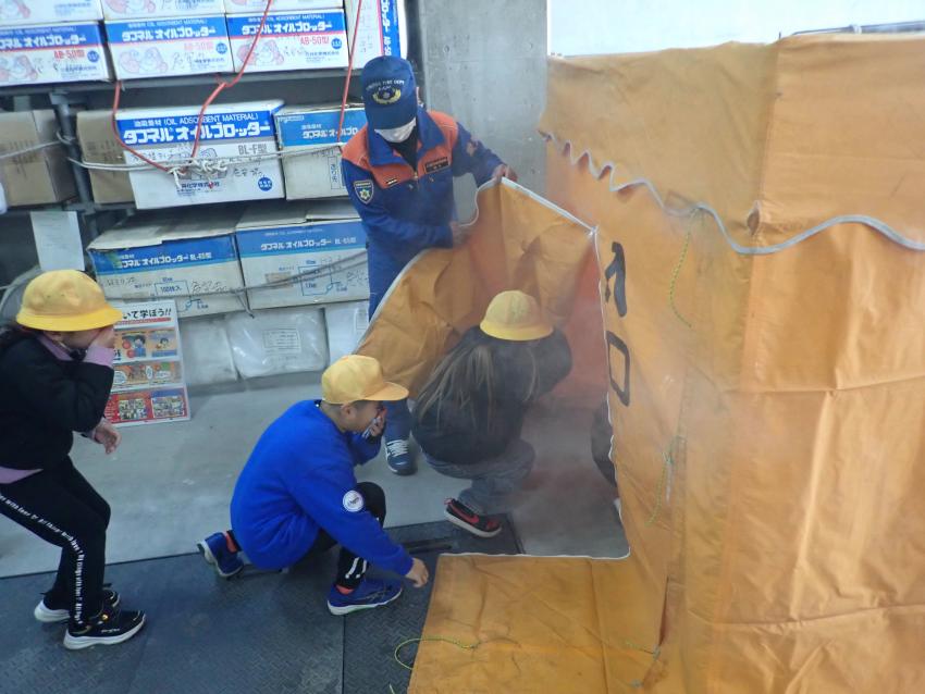 煙体験ハウスに入る小学生