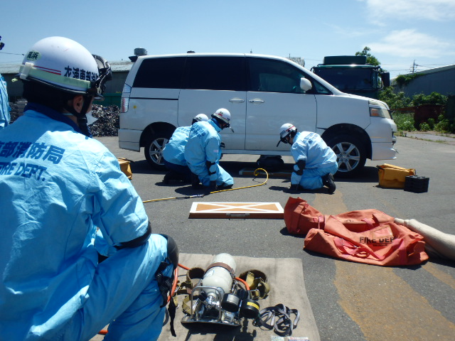 エアージャッキで車両を持ち上げる消防隊員